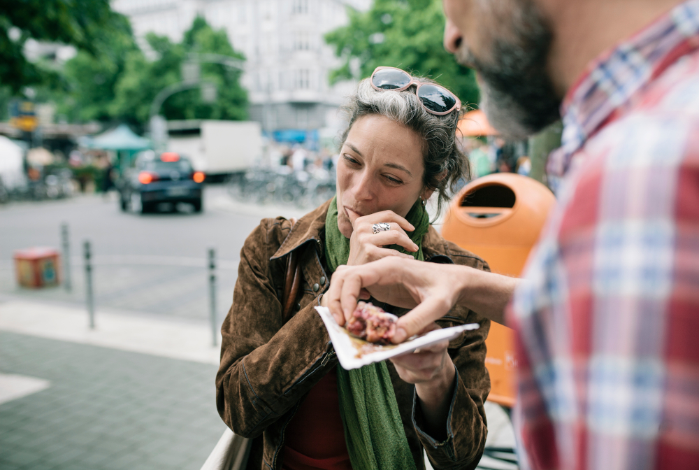A Woman Enjoying Streetfood With Her Partner